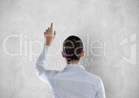 Rear view of businesswoman pointing on white wall