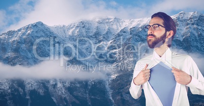 Hipster tearing shirt against snowcapped mountains