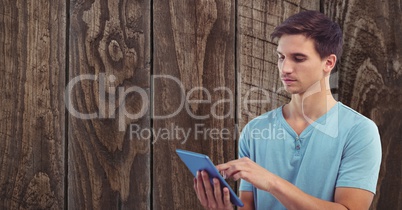 Young man using tablet PC against wall