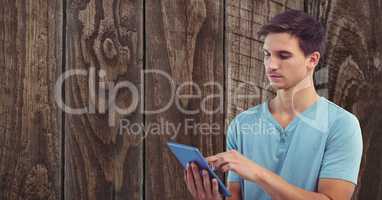 Young man using tablet PC against wall