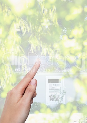 Hand pointing in  air of trees and house