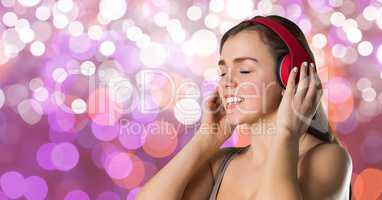 Female hipster listening to music on headphones against bokeh