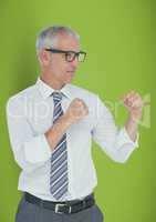 Confident businessman standing in fighting stance against green background