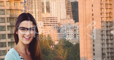 Smiling young woman wearing eyeglasses against buildings