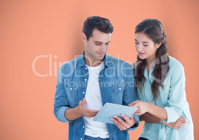 Business people using digital tablet against orange background