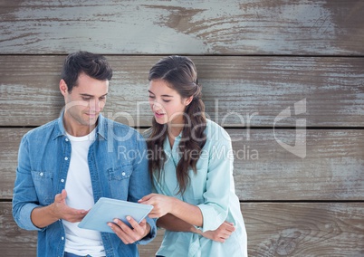 Business people discussing over tablet PC over wooden wall