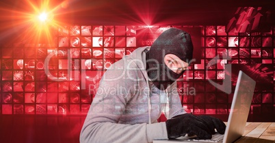 Digital composite image of hacker using laptop