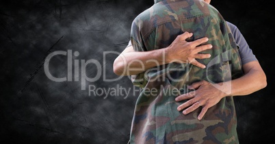 Soldier hugging mid section against black grunge background