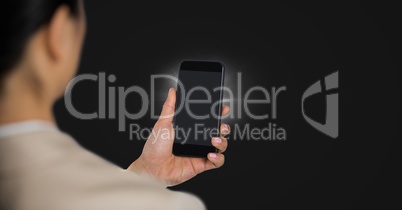 Business womn over shoulder with phone and flare against dark grey background