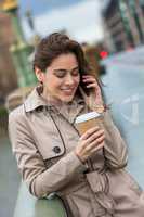 Woman Drinking Coffee Talking on Cell Phone, London, England