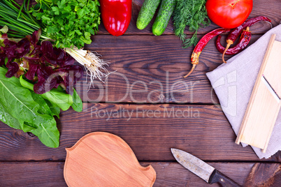 Fresh vegetables and green lettuce leaves on a wooden table
