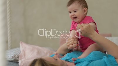Adorable baby girl laughing in sunny bedroom