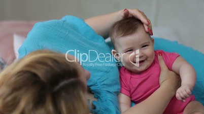 Loving mother stroking adorable baby girl head