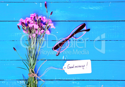 A bouquet of pink carnations with a paper tag