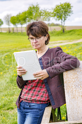 Woman with tablet pc in nature