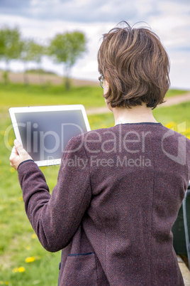 Woman with tablet pc in nature