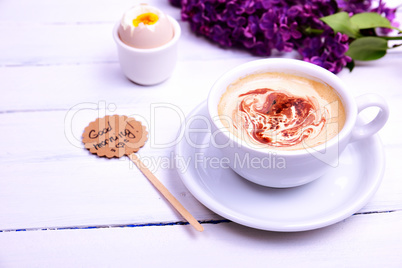 Cup of cappuccino with a saucer on a white wooden background