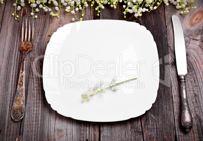 Empty white plate with iron cutlery