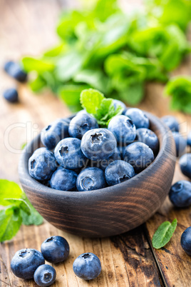 Fresh blueberries in bowl on wooden table