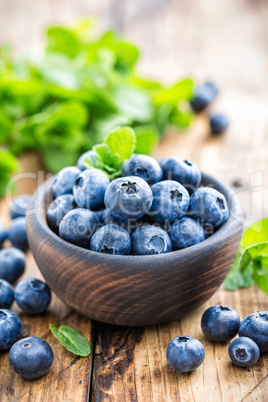 Fresh blueberries in bowl on wooden table