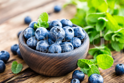 Fresh blueberries in bowl on wooden table