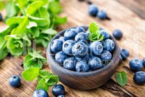 Fresh blueberries in bowl on wooden table