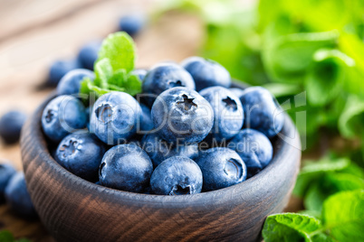 Fresh blueberries in bowl on wooden table