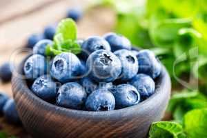 Fresh blueberries in bowl on wooden table