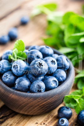 Fresh blueberries in bowl on wooden table