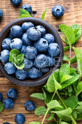 Fresh blueberries in bowl on wooden table