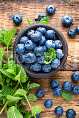 Fresh blueberries in bowl on wooden table