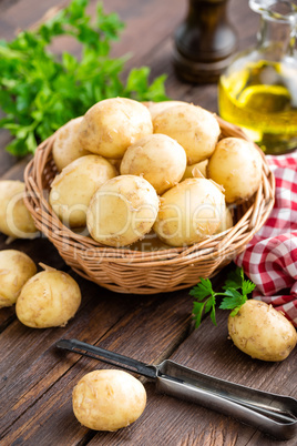 Raw potato in basket on wooden table closeup