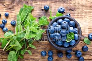 Fresh blueberries in bowl on wooden table