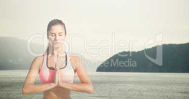 Double exposure of woman meditating against lake