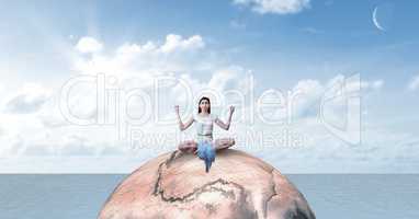 Woman with arms raised meditating on rock