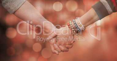 Cropped image of couple holding hands against bokeh