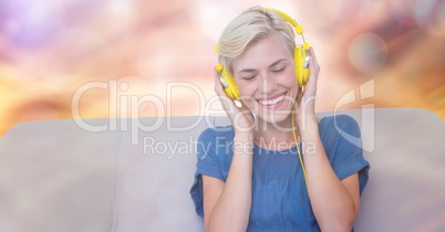 Happy woman listening to music on sofa