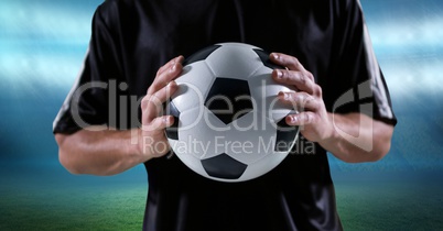 Midsection of player holding soccer ball