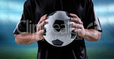 Midsection of player holding soccer ball