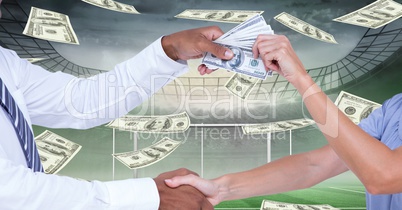 Midsection of people shaking hands while passing money at football stadium representing corruption