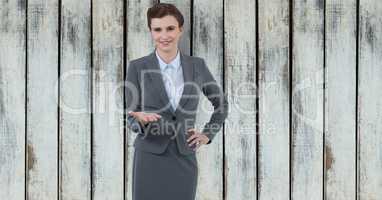 Confident businesswoman offering hand against wooden wall