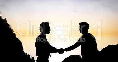 Silhouette businessmen shaking hands during sunset