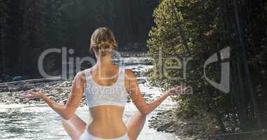 Double exposure of woman meditating on river at forest