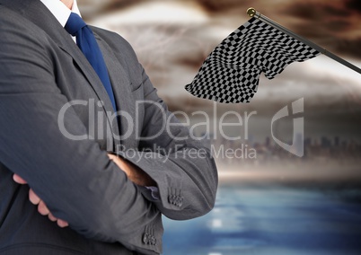 businessman with his hands folded with checker flag  and the city behind him