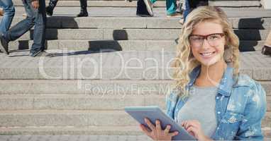 Female hipster using tablet PC while people walking in background