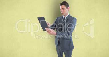 Businessman holding tablet PC over colored background