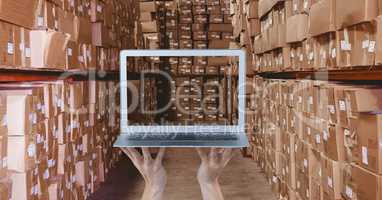 Hands taking picture of boxes with laptop at warehouse