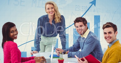 Smiling business people at desk against graph