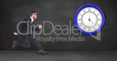 Businessman running while looking at clock