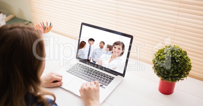 Woman video conferencing with colleagues on laptop